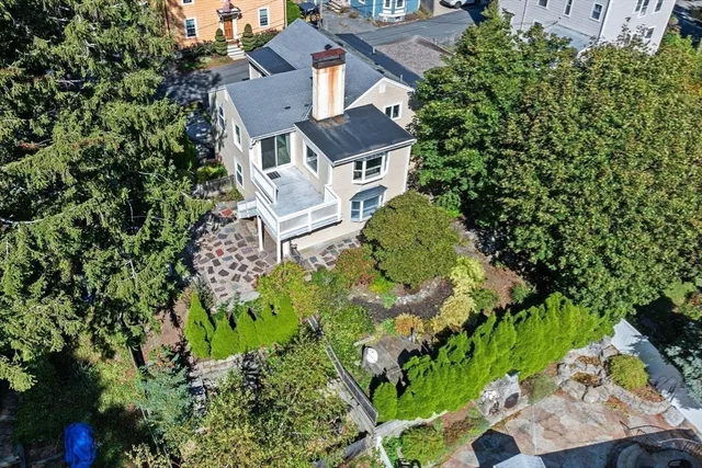 an aerial view of a house with a yard and large trees