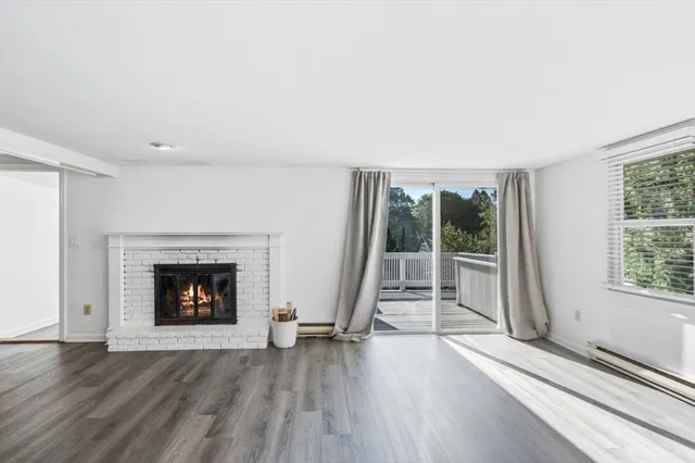 an empty room with wooden floor and fireplace