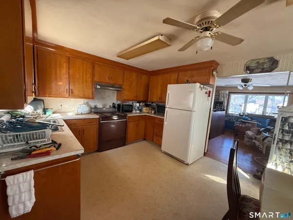 a kitchen with a refrigerator a stove top oven a sink and cabinets