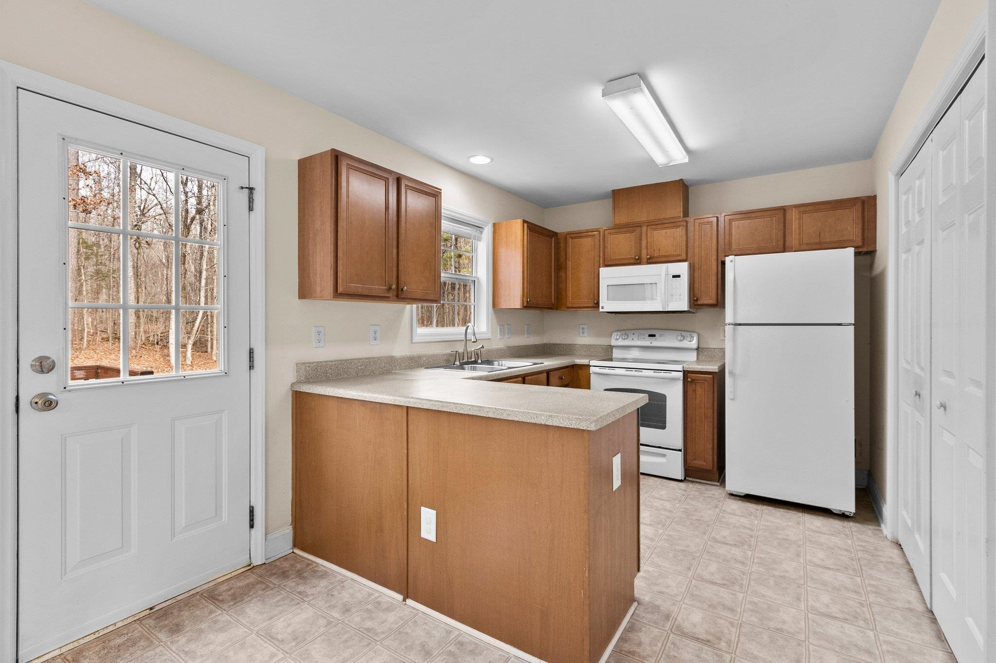 6041 Burgundy Road Durham, NC 27712 - Photo 12 of 45 a kitchen with a refrigerator a stove top oven and a sink