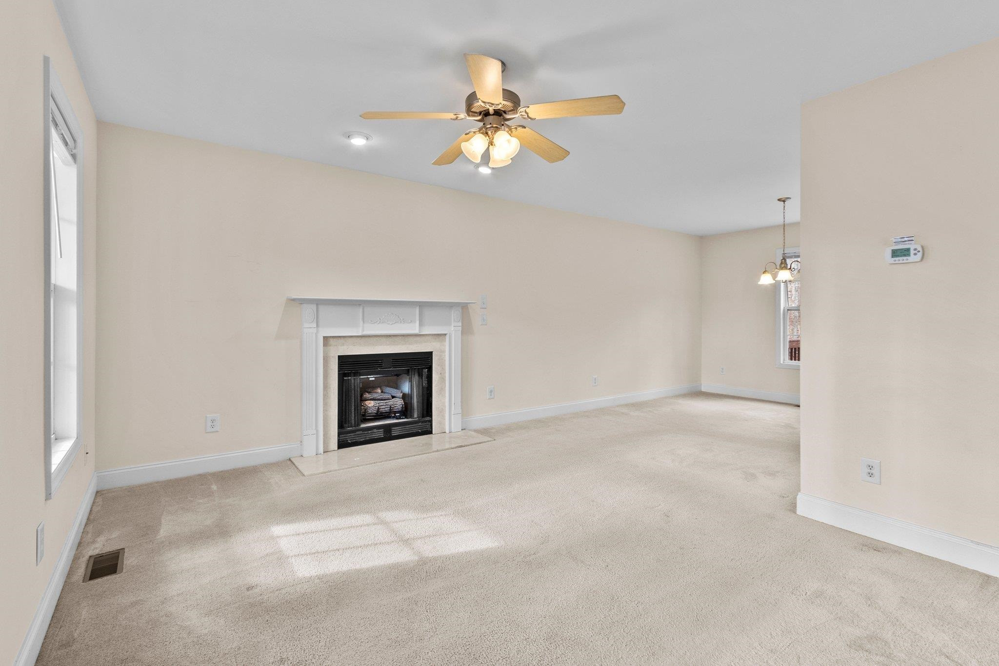 6041 Burgundy Road Durham, NC 27712 - Photo 7 of 45 a view of a livingroom with a ceiling fan and a fireplace