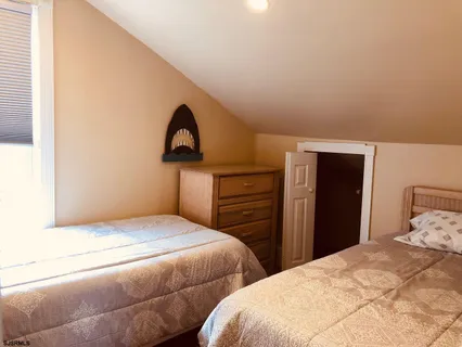 a bedroom with two bed and a painting on the wall