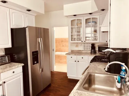 a kitchen with a refrigerator sink and cabinets