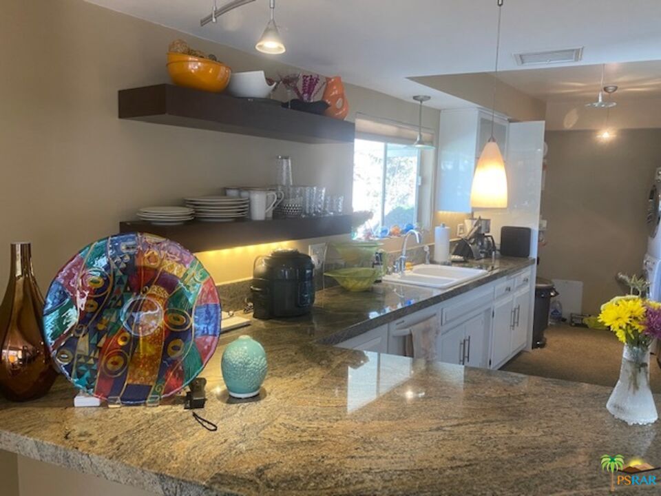 2033 Ramon Road, Unit 4B Palm Springs, CA 92264 - Photo 19 of 44 a bathroom with a granite countertop sink and a mirror
