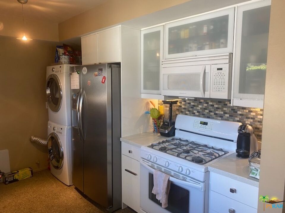 2033 Ramon Road, Unit 4B Palm Springs, CA 92264 - Photo 22 of 44 a kitchen with a stove a refrigerator and wooden cabinets