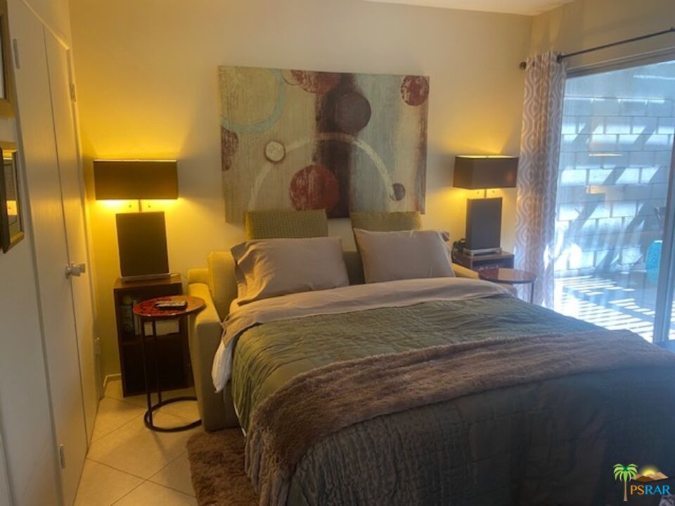 2033 Ramon Road, Unit 4B Palm Springs, CA 92264 - Photo 26 of 44 a bedroom with a bed and lamp with window