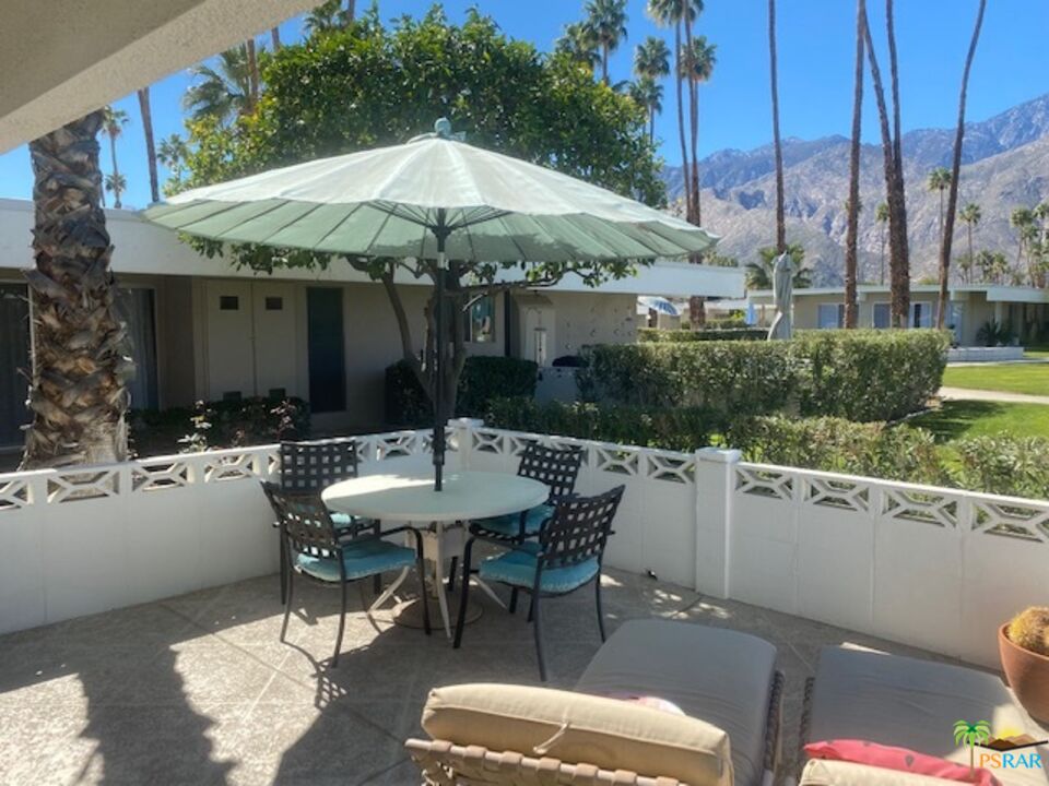 2033 Ramon Road, Unit 4B Palm Springs, CA 92264 - Photo 42 of 44 a patio with a table and chairs under an umbrella