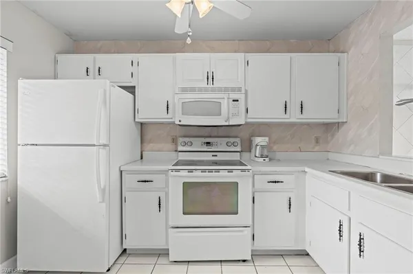a kitchen with cabinets stainless steel appliances and sink