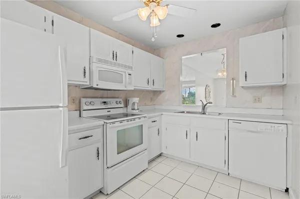 a kitchen with white cabinets stainless steel appliances and a sink