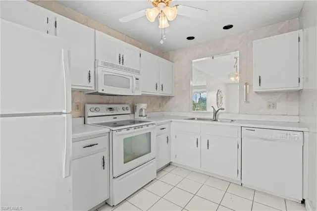 a kitchen with white cabinets stainless steel appliances and a sink