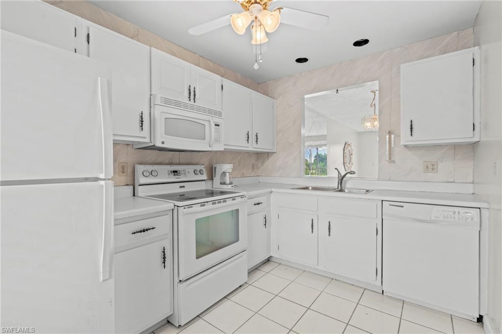 6184 Michelle Way, Unit 243 Fort Myers, FL 33919 - Photo 17 of 21 a kitchen with white cabinets stainless steel appliances and a sink