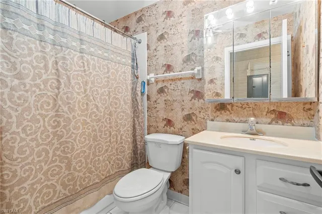 a bathroom with a toilet sink shower and mirror