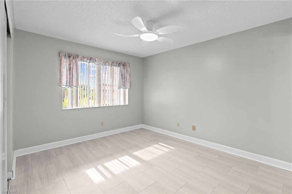 6184 Michelle Way, Unit 243 Fort Myers, FL 33919 - Photo 9 of 21 an empty room with windows and ceiling fan