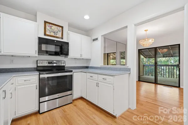 a kitchen with granite countertop a stove a sink and a microwave