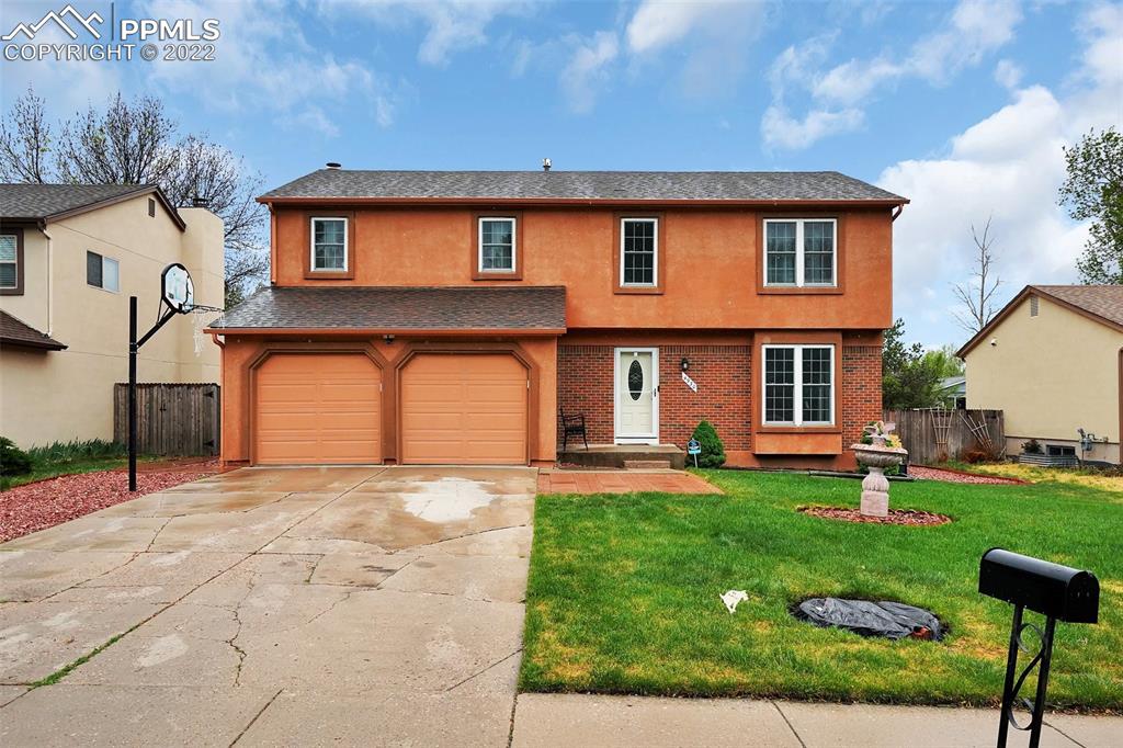 a front view of a house with a yard and garage