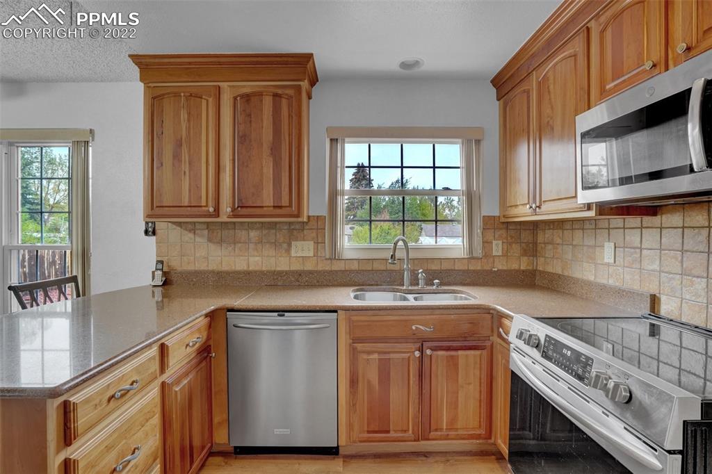 4930 Harvest Road Colorado Springs, CO 80917 - Photo 12 of 39 a kitchen with stainless steel appliances granite countertop a sink stove and microwave