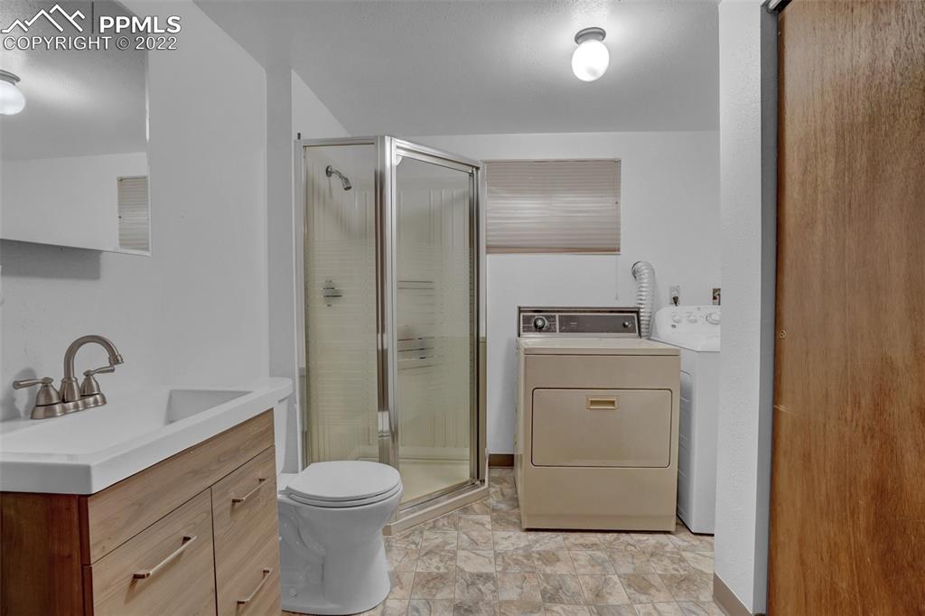 4930 Harvest Road Colorado Springs, CO 80917 - Photo 16 of 39 a bathroom with a toilet sink vanity and mirror