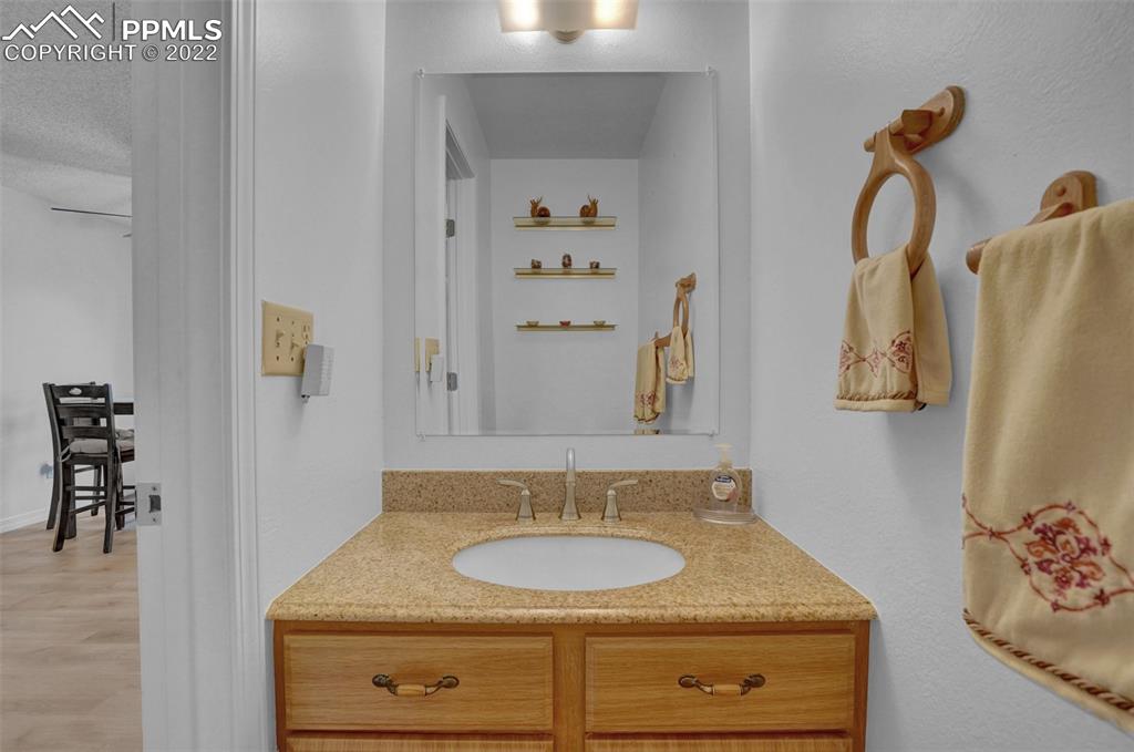 4930 Harvest Road Colorado Springs, CO 80917 - Photo 19 of 39 a bathroom with a granite countertop sink and a mirror