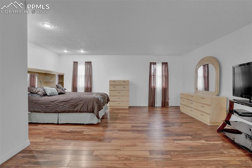4930 Harvest Road Colorado Springs, CO 80917 - Photo 21 of 39 a spacious bedroom with a large bed and a dresser