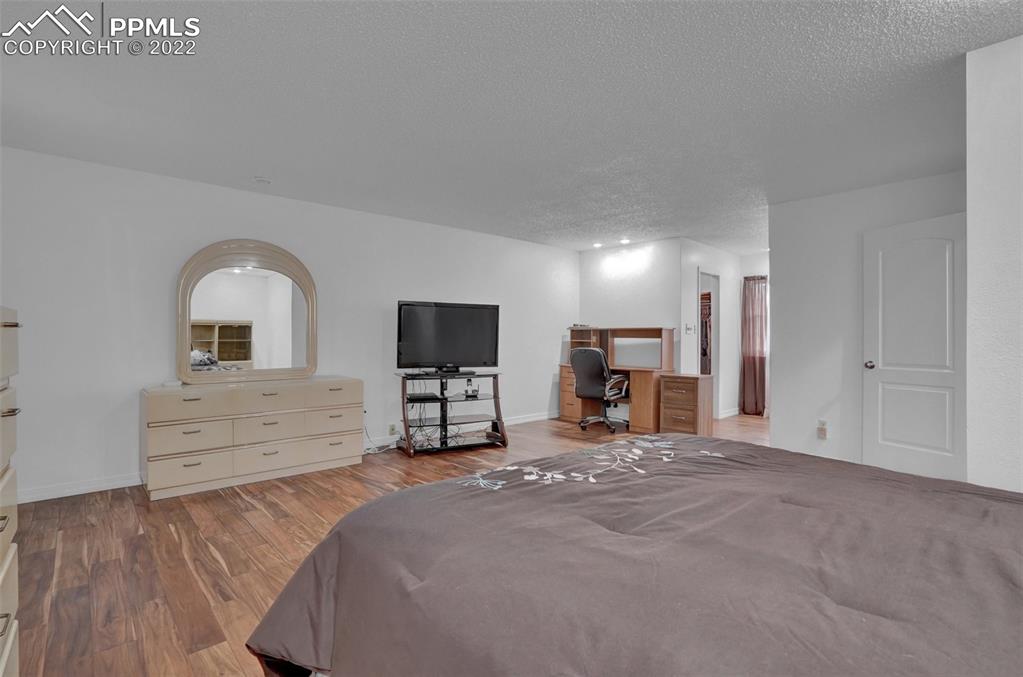 4930 Harvest Road Colorado Springs, CO 80917 - Photo 22 of 39 a view of a bedroom with furniture and flat screen tv