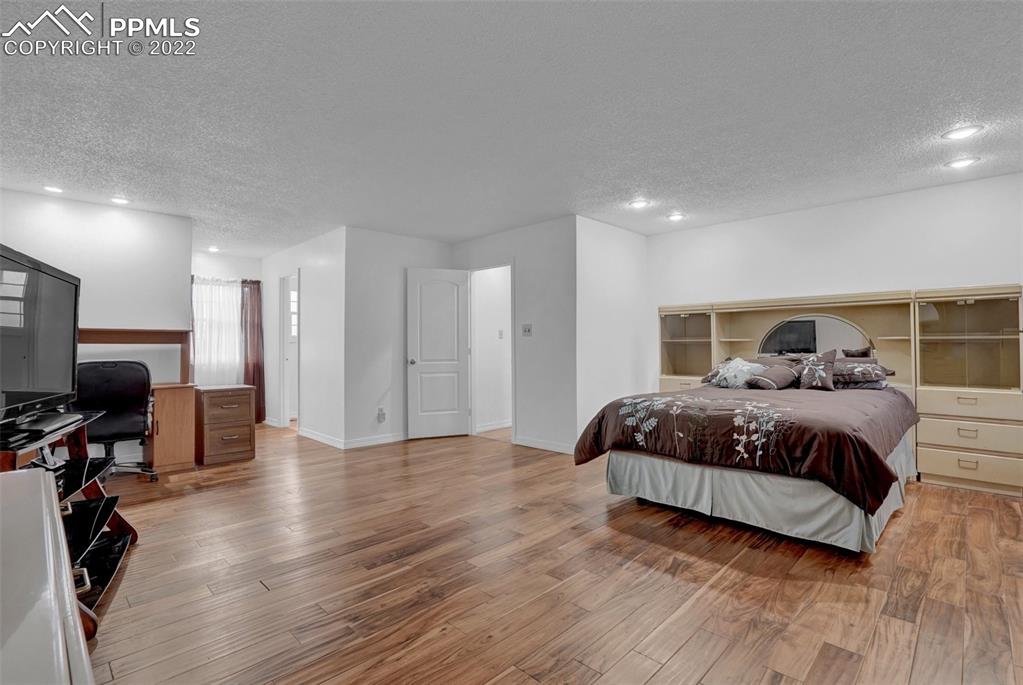 4930 Harvest Road Colorado Springs, CO 80917 - Photo 23 of 39 a bedroom with a bed a flat screen tv and dresser