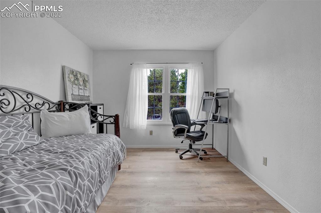 4930 Harvest Road Colorado Springs, CO 80917 - Photo 25 of 39 a bedroom with a bed a chair and a large window