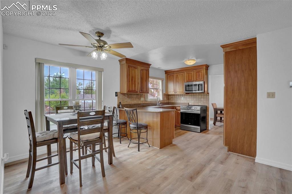 4930 Harvest Road Colorado Springs, CO 80917 - Photo 9 of 39 a kitchen with kitchen island granite countertop a stove a sink a oven with a dining table and chairs