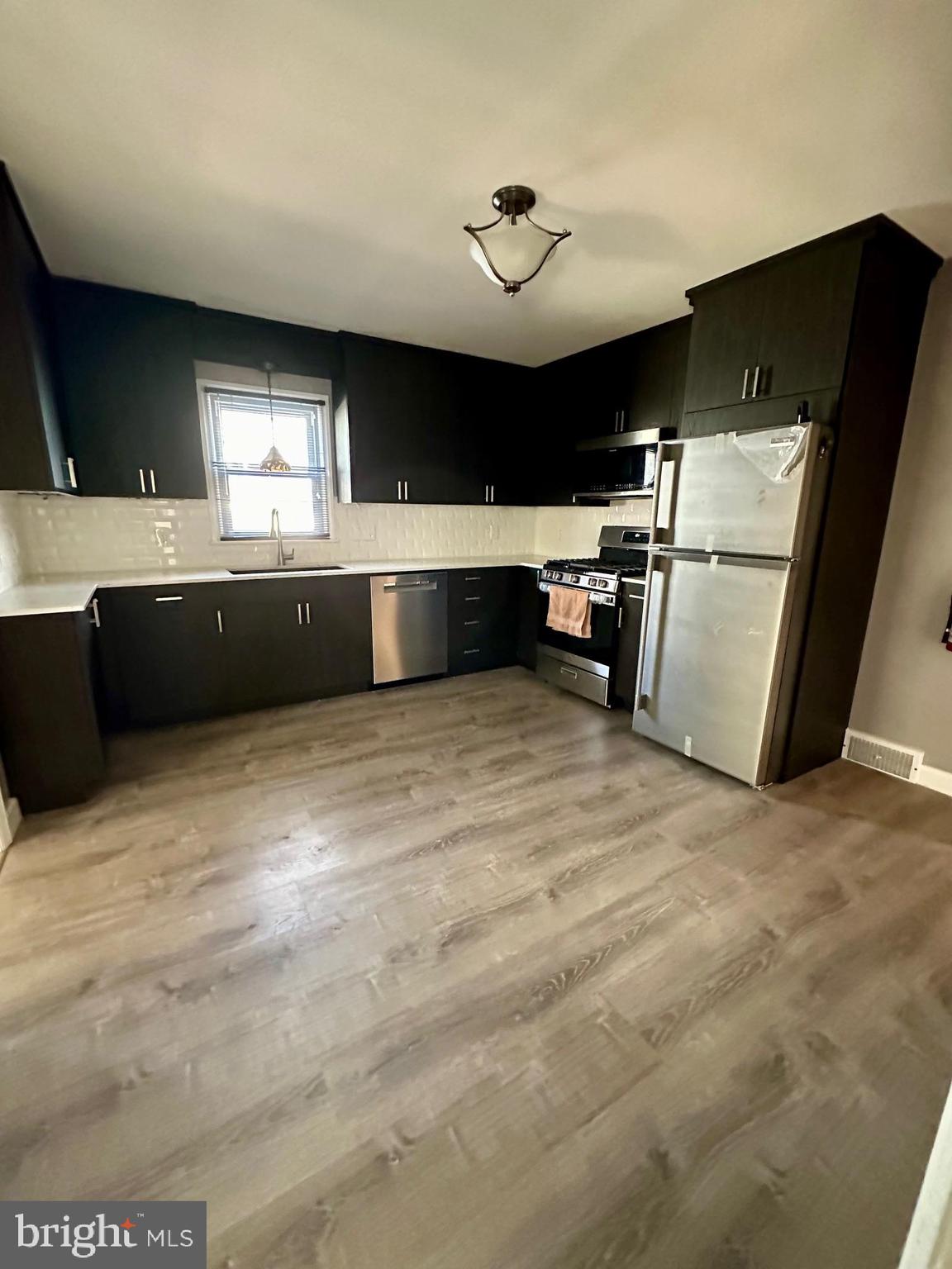 128 Central Avenue Ewing, NJ 08628 - Photo 4 of 15 a kitchen with stainless steel appliances kitchen island sink refrigerator and stove