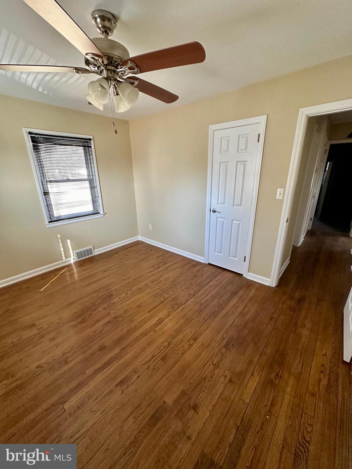 128 Central Avenue Ewing, NJ 08628 - Photo 10 of 15 a view of an empty room with wooden floor and a ceiling fan