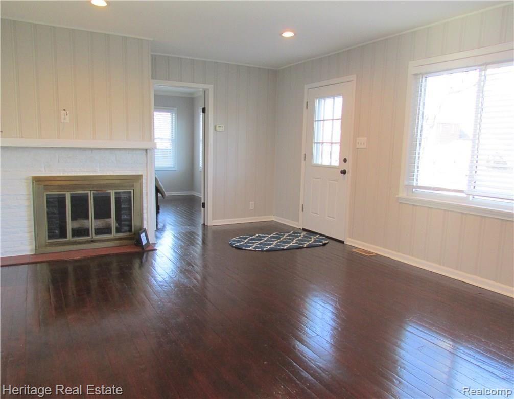 Fabulous freshly painted living room with beautifully refinished hardwood floors and cozy fireplace