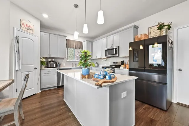 a kitchen with kitchen island white cabinets and stainless steel appliances