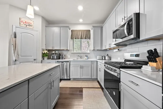a kitchen with stainless steel appliances granite countertop a sink and a stove