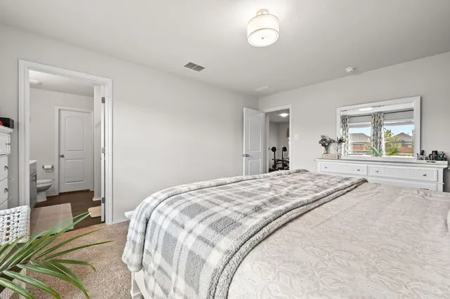 a spacious bedroom with a bed and a large mirror