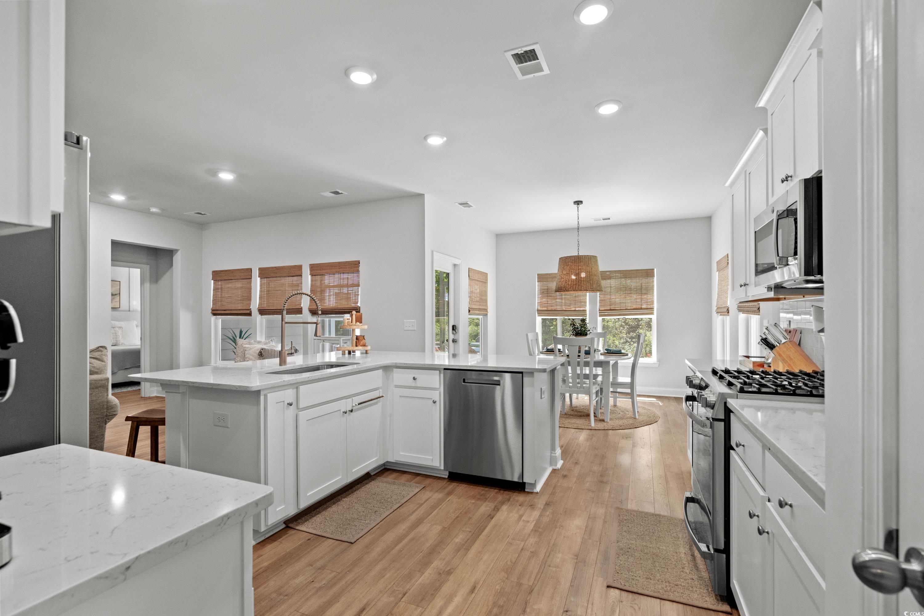 1016 Saluda River Road Murrells Inlet, SC 29576 - Photo 8 of 38 Kitchen with light wood-style floors, white cabine