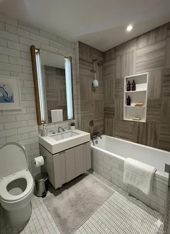 a bathroom with a granite countertop sink and a bathtub