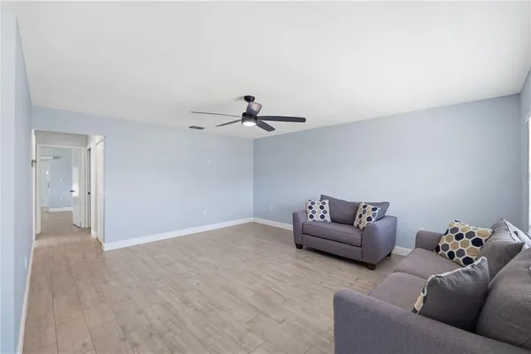 a living room with furniture and a ceiling fan