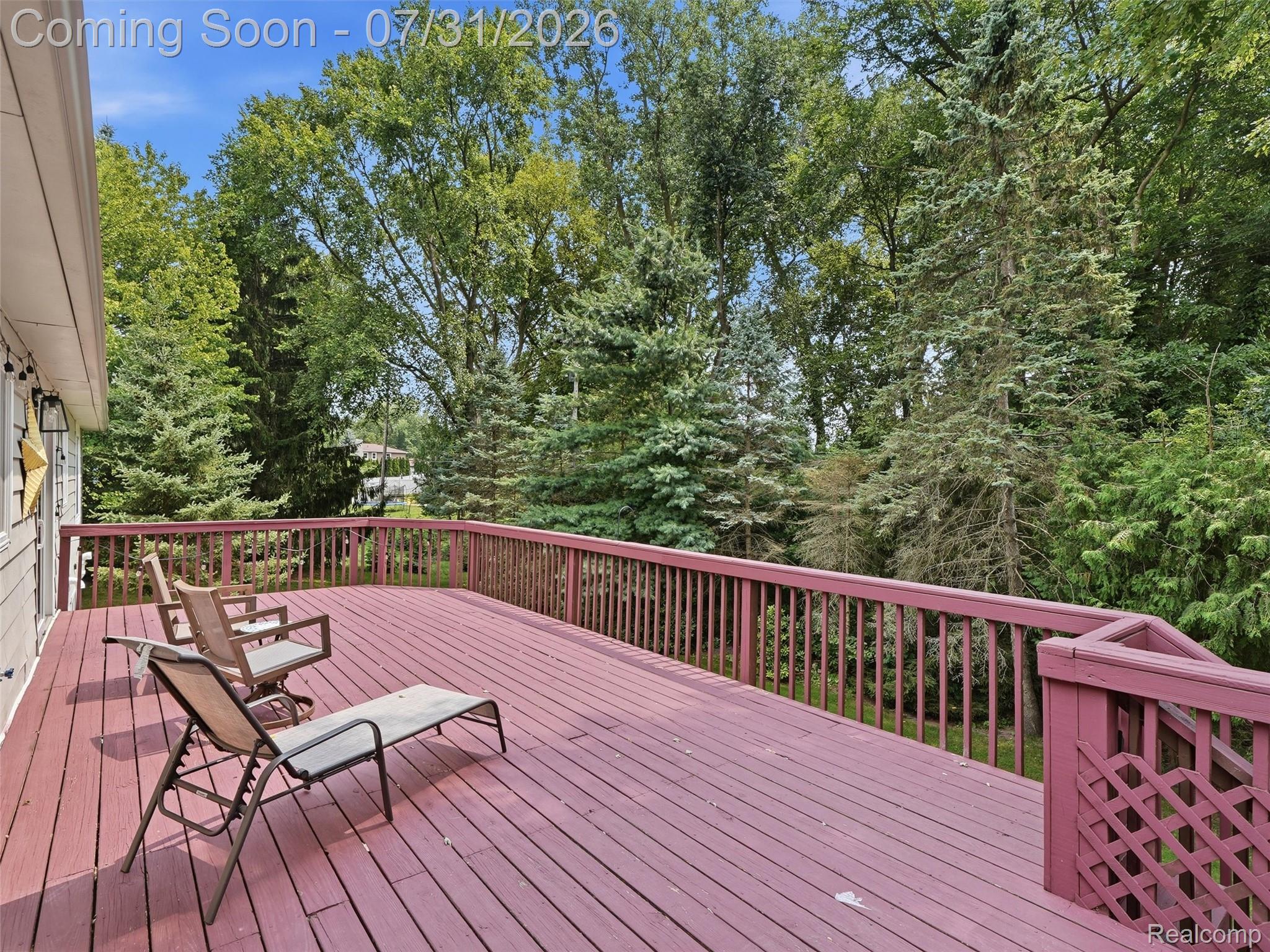 138 Aintree Road Rochester, MI 48306 - Photo 48 of 53 Expansive outdoor deck space featuring a reddish-brown wood finish, complete with a matching railing system, and surrounded by mature trees