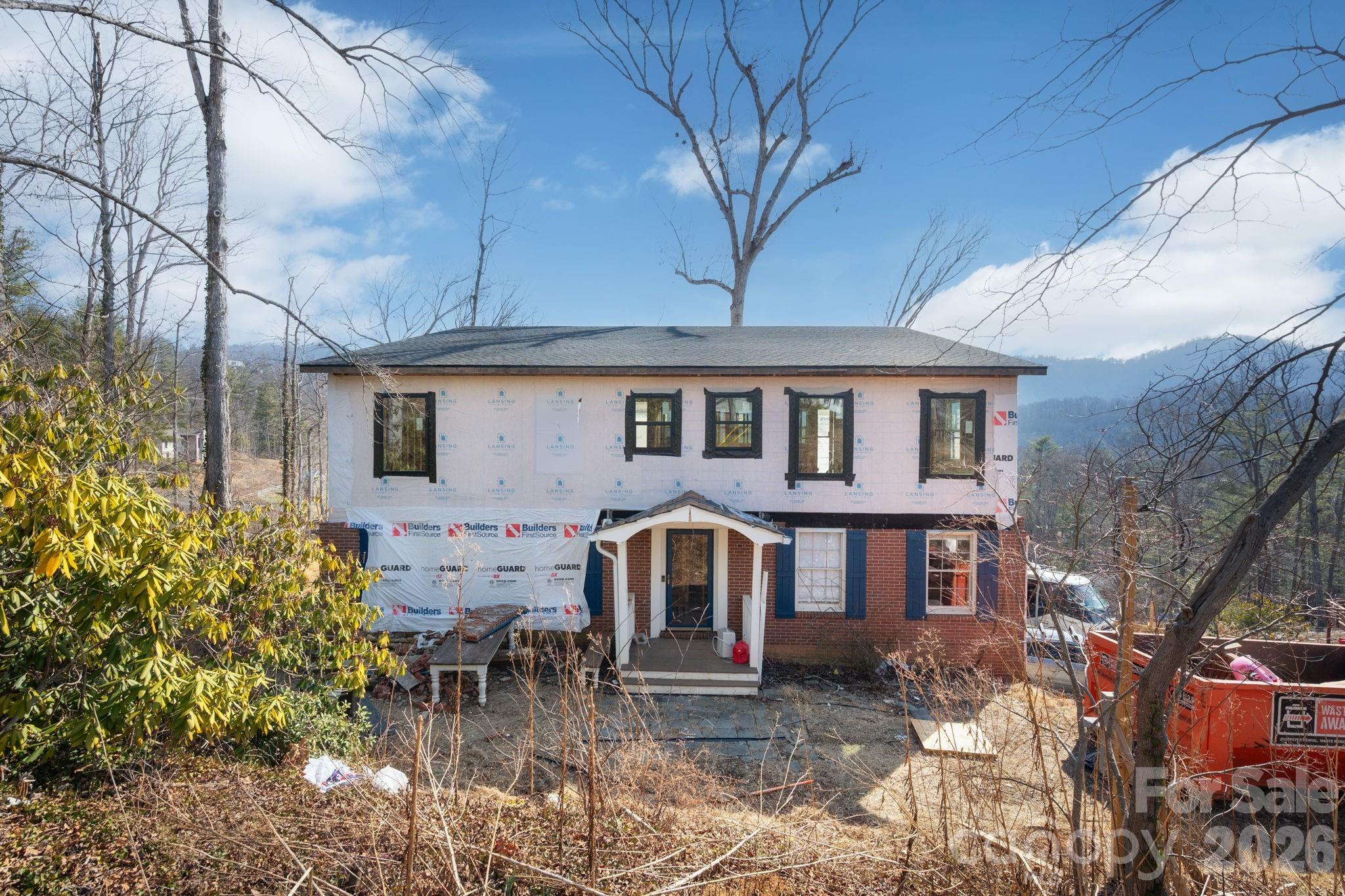 a front view of a house with yard and sitting area