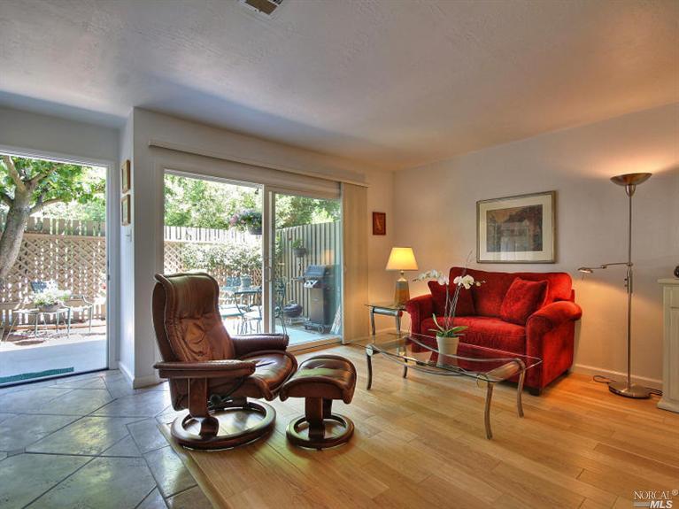 a living room with furniture floor to ceiling window and wooden floor