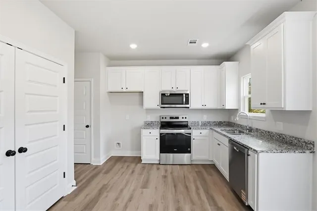 a kitchen with stainless steel appliances granite countertop a stove a sink and a refrigerator