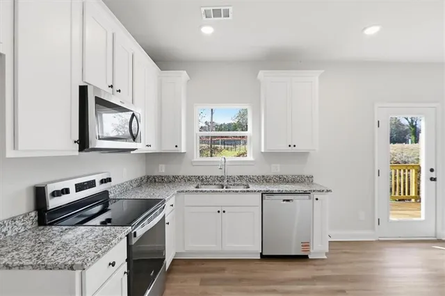 a kitchen with granite countertop a sink a stove and wooden cabinets