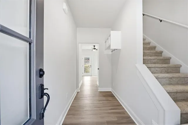 a view of a hallway with wooden floor and staircase