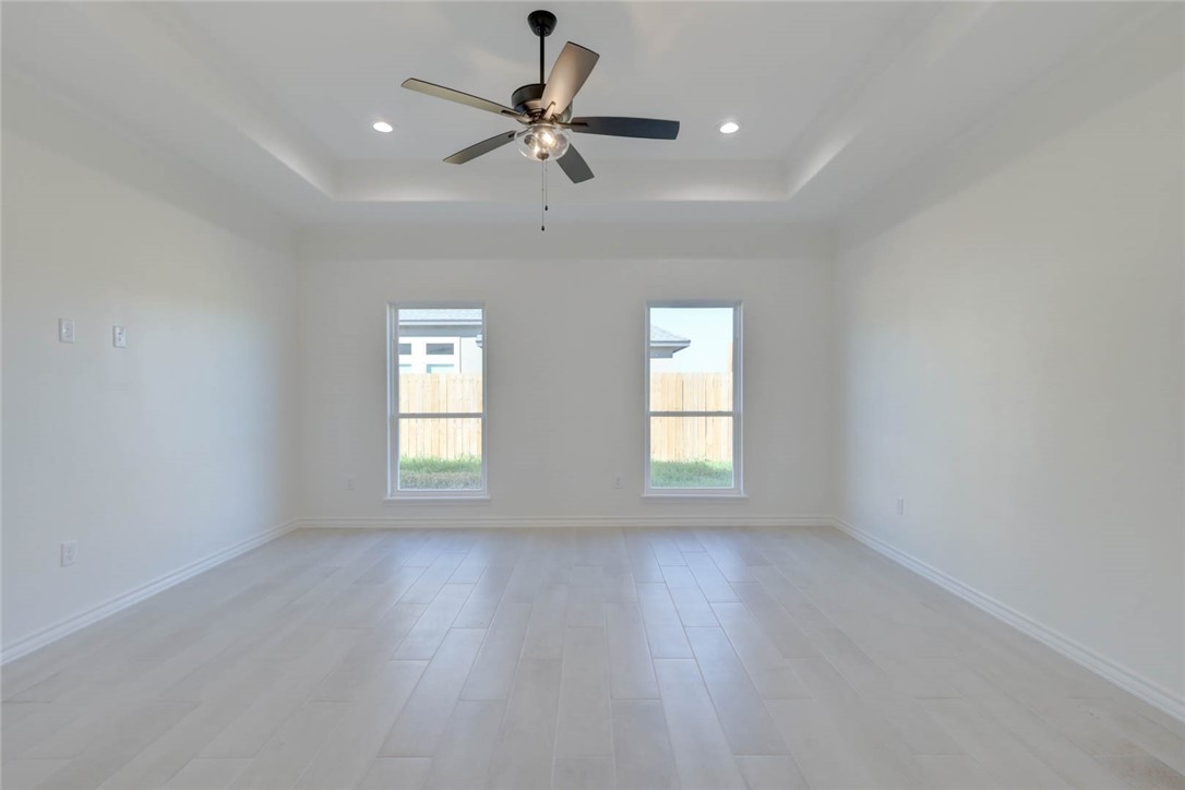 141 Amethyst Street Portland, TX 78374 - Photo 11 of 22 an empty room with wooden floor fan and windows