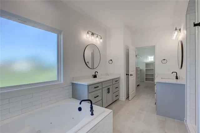 a bathroom with a tub sink and mirror