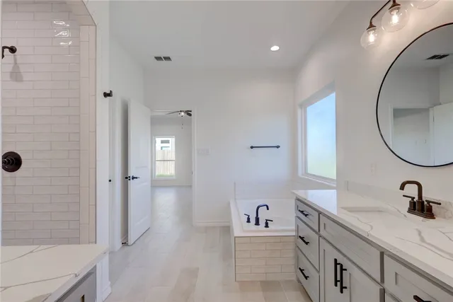 a spacious bathroom with a sink a mirror a vanity and a shower