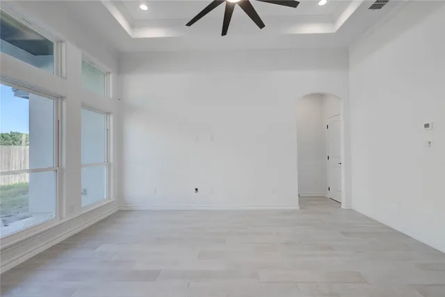 an empty room with a ceiling fan and window