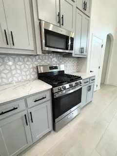 a kitchen with stainless steel appliances white cabinets and a stove top oven
