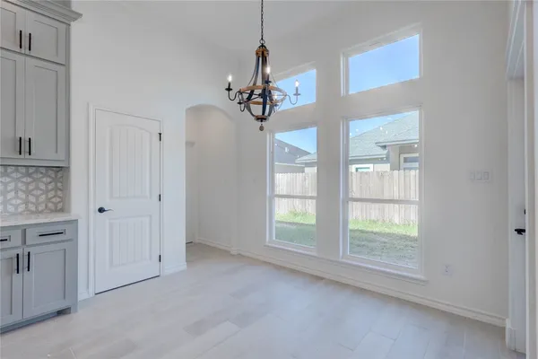 a view of a livingroom with a chandelier fan and windows