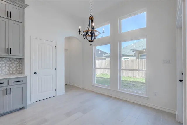 a view of a livingroom with a chandelier fan and windows