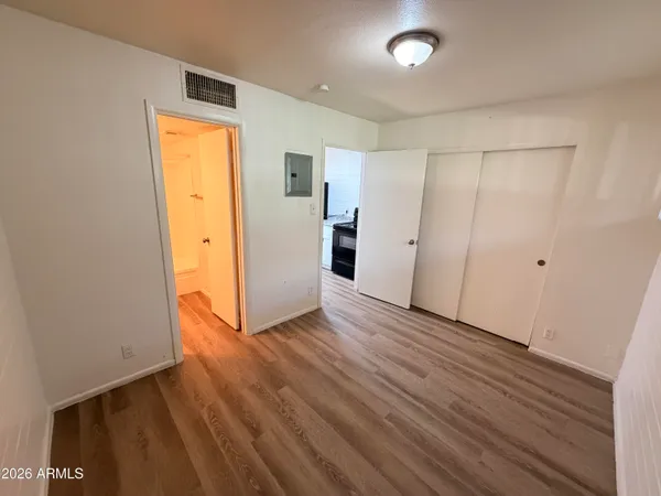 an empty room with wooden floor and closet